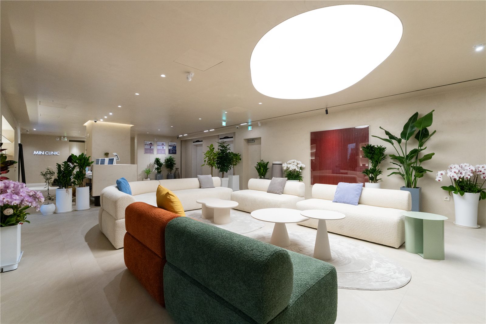 Min Clinic lounge with curved sofas under an oval ceiling light